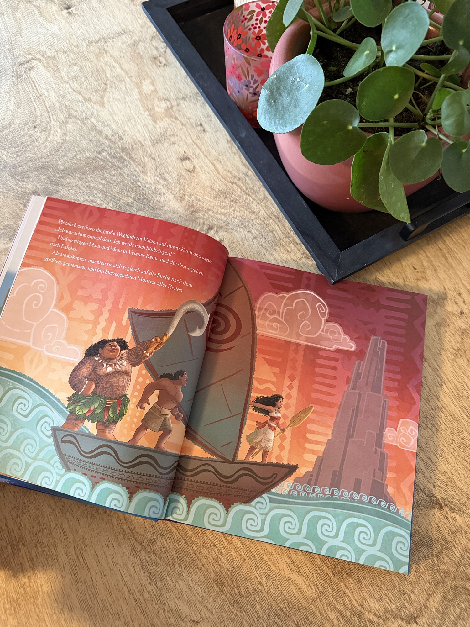 Bunte Illustration aus dem Kinderbuch "Das große Disney-Geschichtenbuch" mit den Charakteren Viana, Maui und Moni auf einem Boot vor einem farbenfrohen Hintergrund.